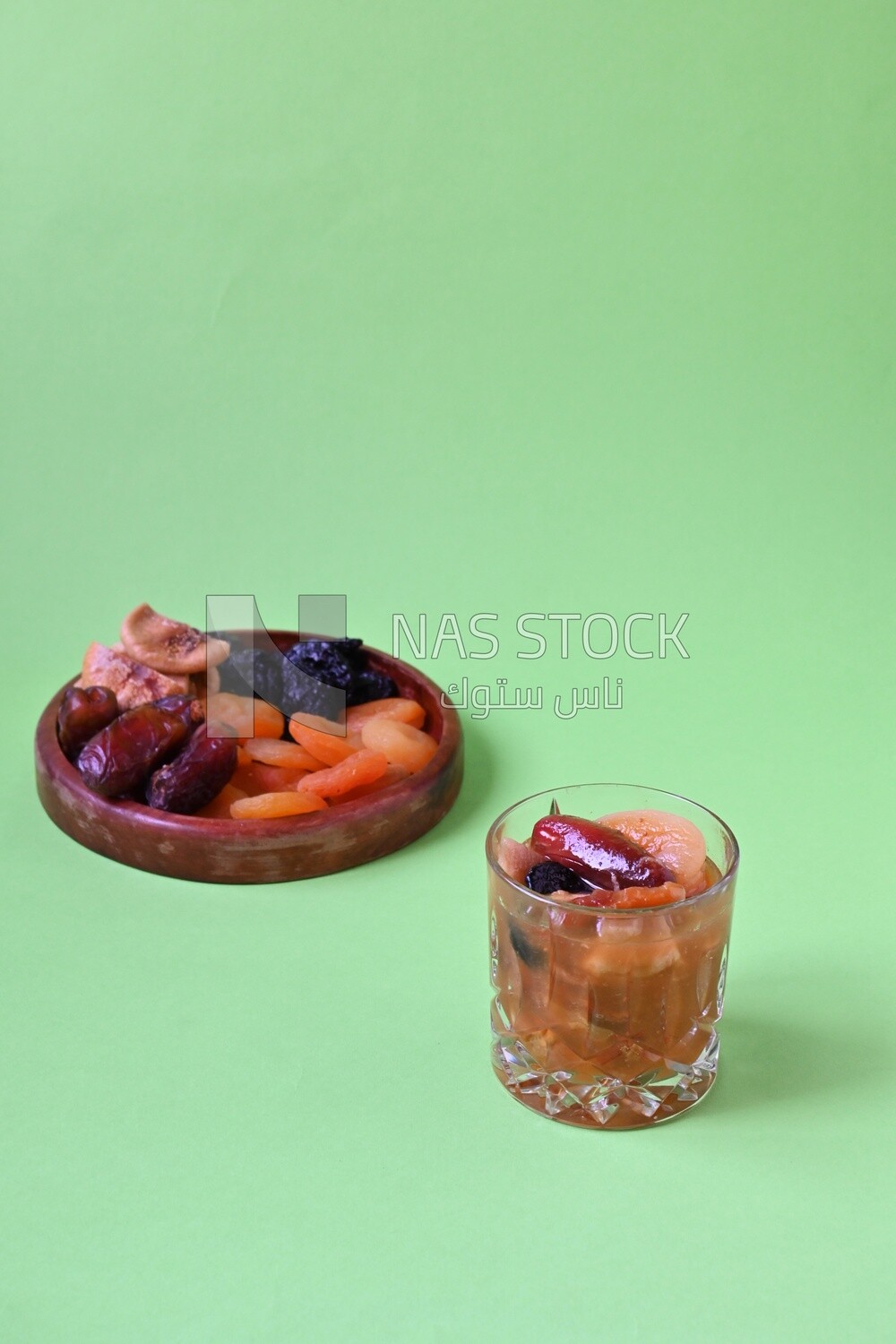 Khashaf cup with a wooden plate with dried fruits, nuts salad, delicious dessert, Ramadan juice, delicious juice, traditional juice