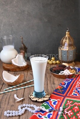 Cup of sobia beside a coconut with a plate of dried fruits(khoshaf), delicious dessert, Ramadan juice, delicious juice, traditional juice