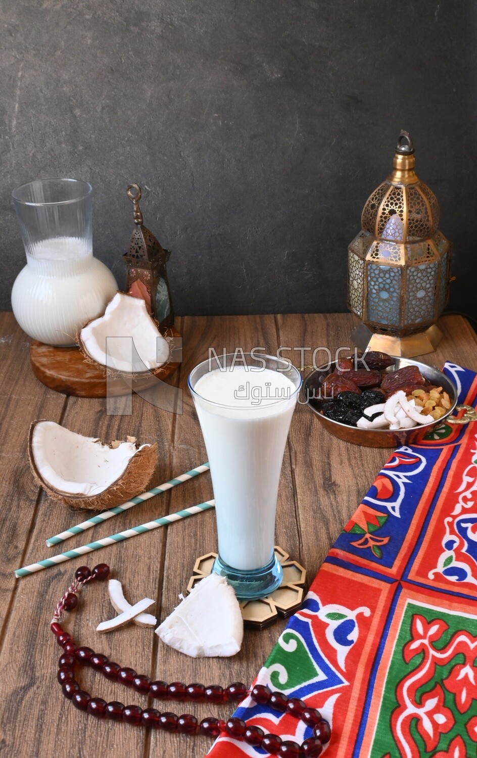 Cup of sobia beside a coconut with a plate of dried fruits(khoshaf), delicious dessert, Ramadan juice, delicious juice, traditional juice