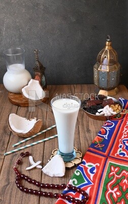 Cup of sobia beside a coconut with a plate of dried fruits(khoshaf), delicious dessert, Ramadan juice, delicious juice, traditional juice
