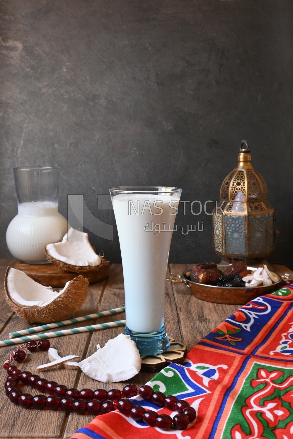 Cup of sobia beside a coconut with a plate of dried fruits(khoshaf), delicious dessert, Ramadan juice, delicious juice, traditional juice
