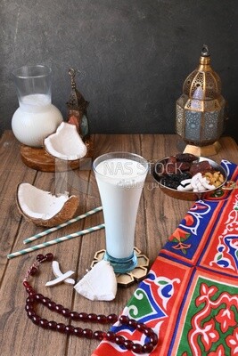 Cup of sobia beside a coconut with a plate of dried fruits(khoshaf), delicious dessert, Ramadan juice, delicious juice, traditional juice