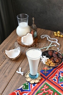 Cup of sobia beside a coconut with a plate of dried fruits(khoshaf), delicious dessert, Ramadan juice, delicious juice, traditional juice