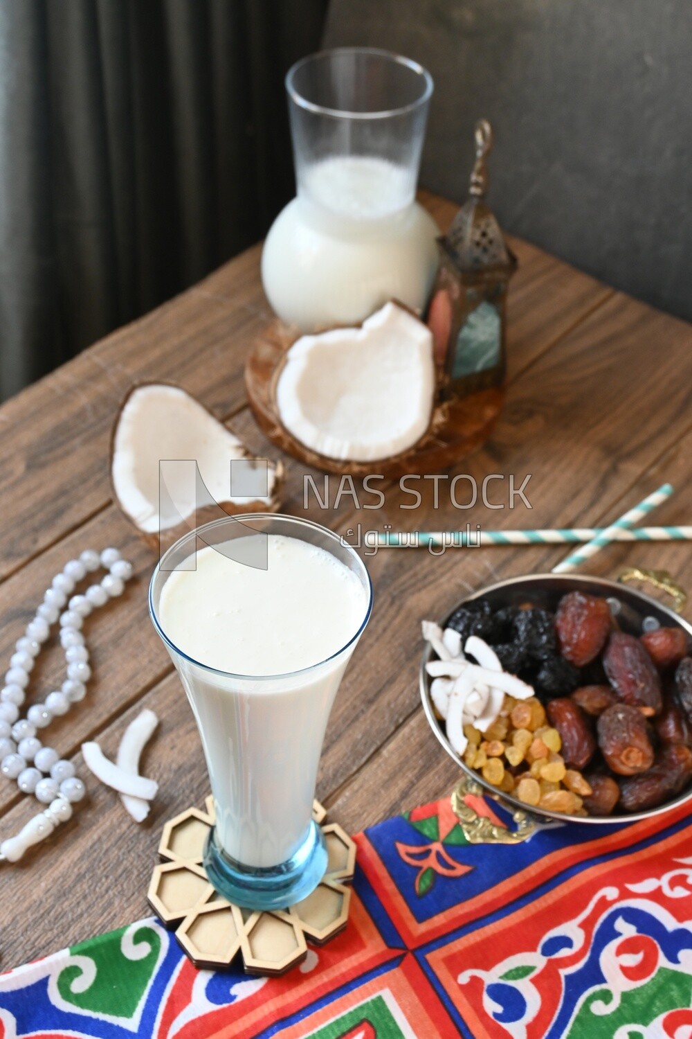 Cup of sobia beside a coconut with a plate of dried fruits(khoshaf), delicious dessert, Ramadan juice, delicious juice, traditional juice