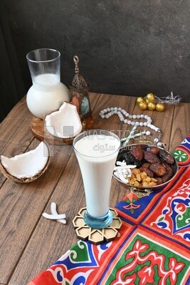 Cup of sobia beside a coconut with a plate of dried fruits(khoshaf), delicious dessert, Ramadan juice, delicious juice, traditional juice