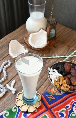 Cup of sobia beside a coconut with a plate of dried fruits(khoshaf), delicious dessert, Ramadan juice, delicious juice, traditional juice