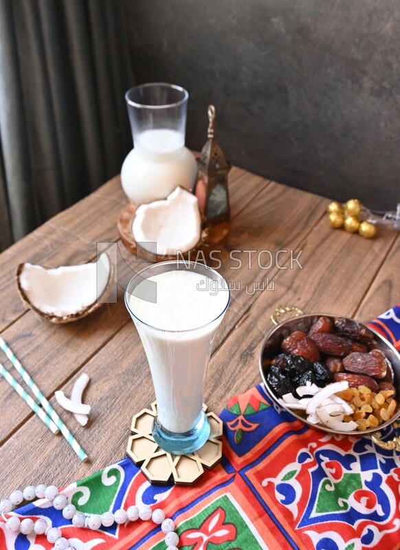 Cup of sobia beside a coconut with a plate of dried fruits(khoshaf), delicious dessert, Ramadan juice, delicious juice, traditional juice