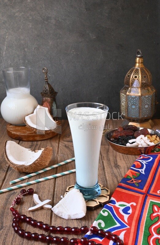 Cup of sobia beside a coconut with a plate of dried fruits(khoshaf), delicious dessert, Ramadan juice, delicious juice, traditional juice