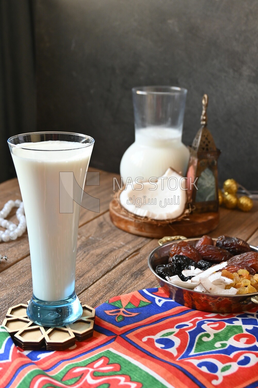Cup of sobia beside a coconut with a plate of dried fruits(khoshaf), delicious dessert, Ramadan juice, delicious juice, traditional juice
