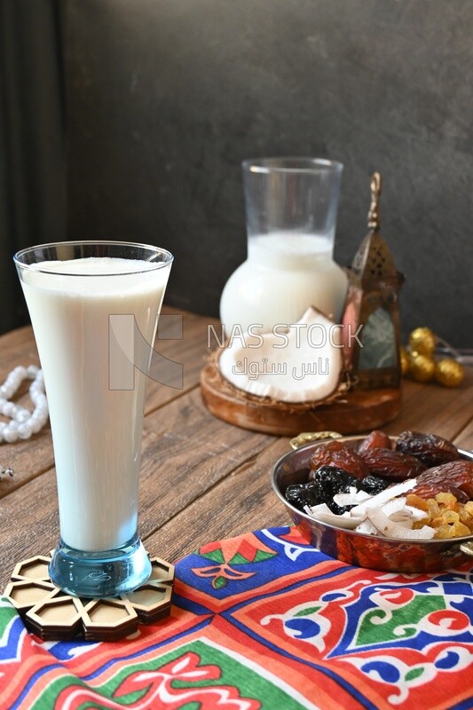 Cup of sobia beside a coconut with a plate of dried fruits(khoshaf), delicious dessert, Ramadan juice, delicious juice, traditional juice