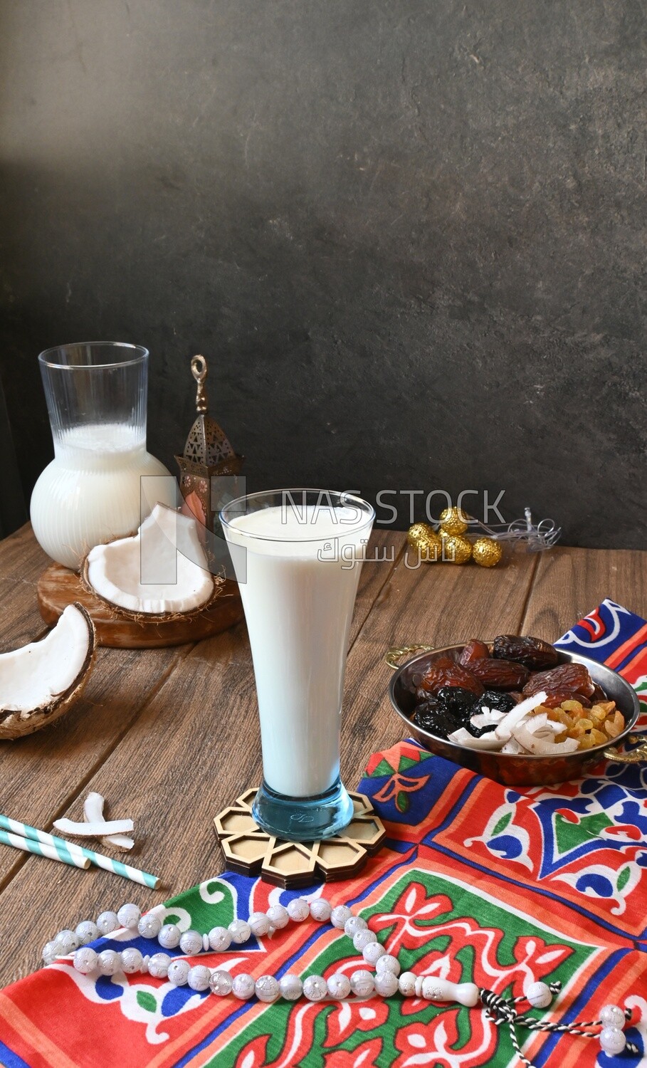 Cup of sobia beside a coconut with a plate of dried fruits(khoshaf), delicious dessert, Ramadan juice, delicious juice, traditional juice