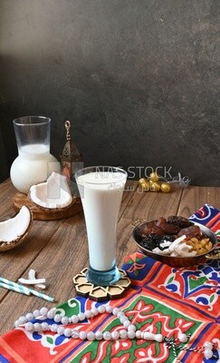 Cup of sobia beside a coconut with a plate of dried fruits(khoshaf), delicious dessert, Ramadan juice, delicious juice, traditional juice