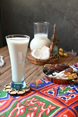 Cup of sobia beside a coconut with a plate of dried fruits(khoshaf), delicious dessert, Ramadan juice, delicious juice, traditional juice