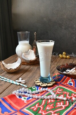 Cup of sobia beside a coconut with a plate of dried fruits(khoshaf), delicious dessert, Ramadan juice, delicious juice, traditional juice