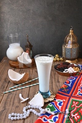 Cup of sobia beside a coconut with a plate of dried fruits(khoshaf), delicious dessert, Ramadan juice, delicious juice, traditional juice