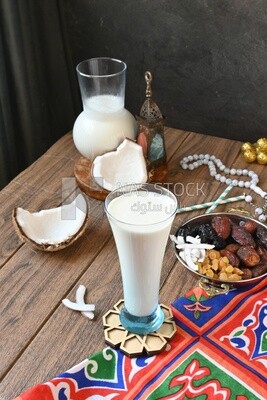 Cup of sobia beside a coconut with a plate of dried fruits(khoshaf), delicious dessert, Ramadan juice, delicious juice, traditional juice