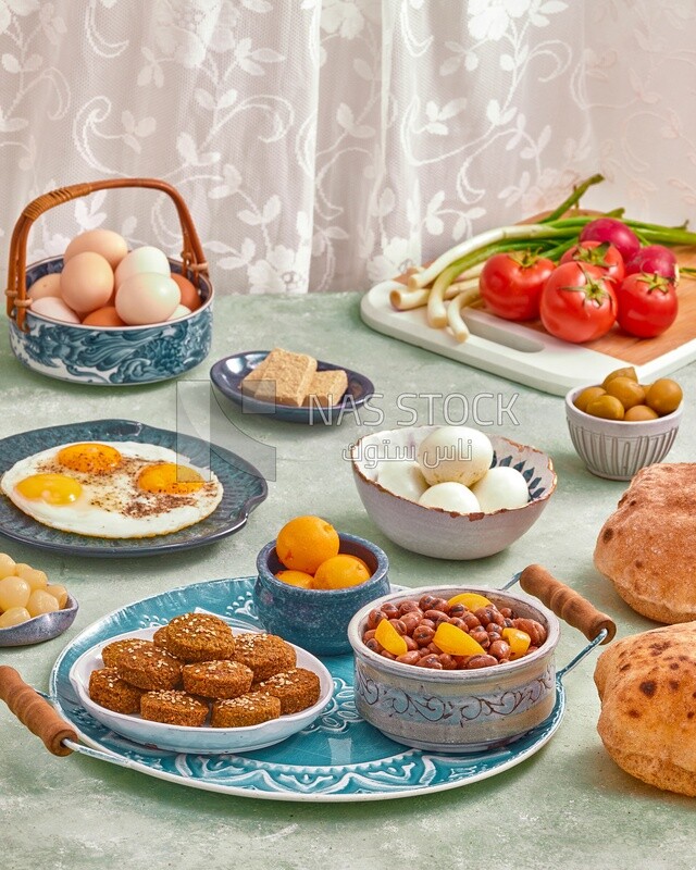 Dish of foul medames, falafel tablets, a plate of fried egg, Arabic breakfast, oriental breakfast, arab restaurant