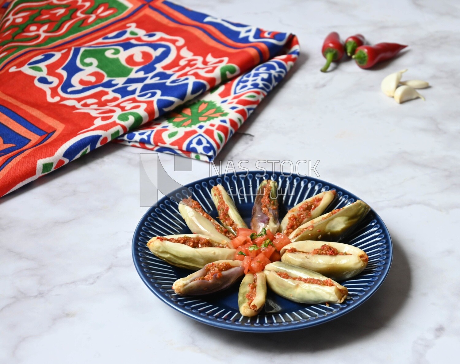 Plate of Pickled eggplant with sauce in it beside garlic and red pepper, Egyptian pickles, Arabic restaurants
