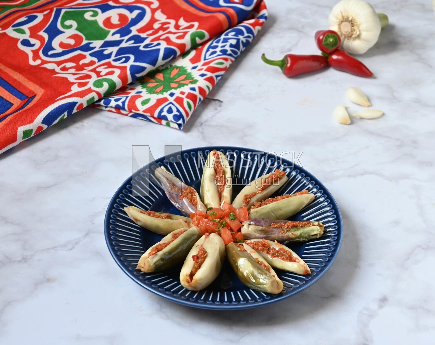 Plate of Pickled eggplant with sauce in it beside garlic and red pepper, Egyptian pickles, Arabic restaurants