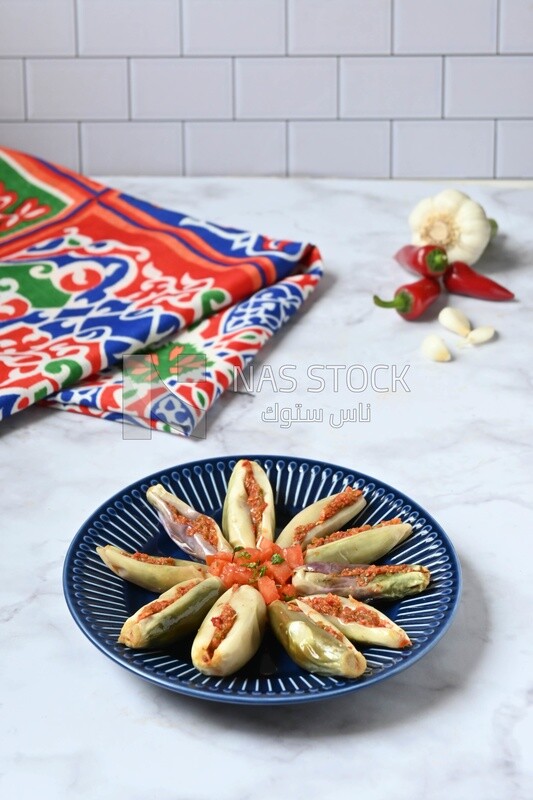Plate of Pickled eggplant with sauce in it beside garlic and red pepper, Egyptian pickles, Arabic restaurants