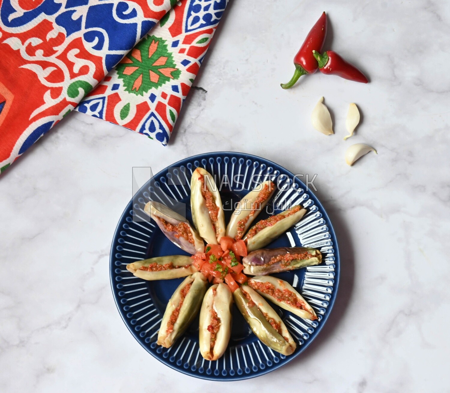 Plate of Pickled eggplant with sauce in it beside garlic and red pepper, Egyptian pickles, Arabic restaurants