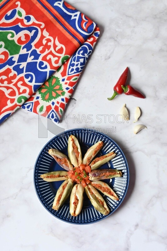 Plate of Pickled eggplant with sauce in it beside garlic and red pepper, Egyptian pickles, Arabic restaurants