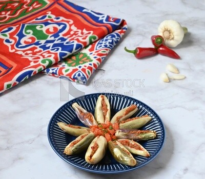 Plate of Pickled eggplant with sauce in it beside garlic and red pepper, Egyptian pickles, Arabic restaurants