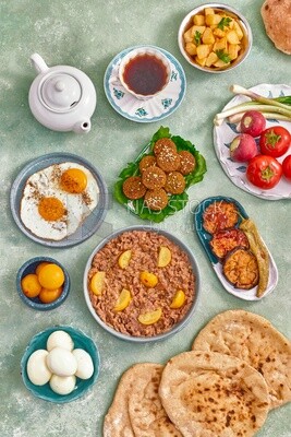 Dish of foul medames, falafel tablets, a plate of fried egg, Arabic breakfast, oriental breakfast, arab restaurant
