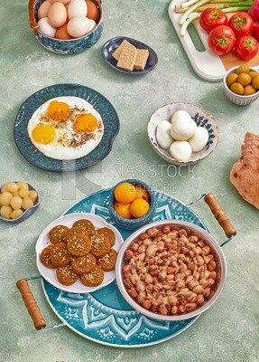 Dish of foul medames, falafel tablets, a plate of fried egg, Arabic breakfast, oriental breakfast, arab restaurant