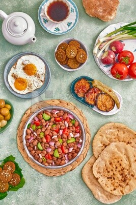 Dish of foul medames, falafel tablets, a plate of fried egg, Arabic breakfast, oriental breakfast, arab restaurant