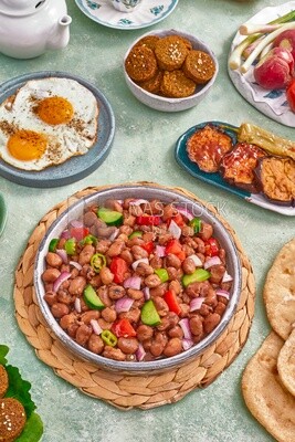 close-up of a dish of foul medames with vegetables, falafel tablets, a plate of fried egg, Arabic breakfast, oriental breakfast, arab restaurant