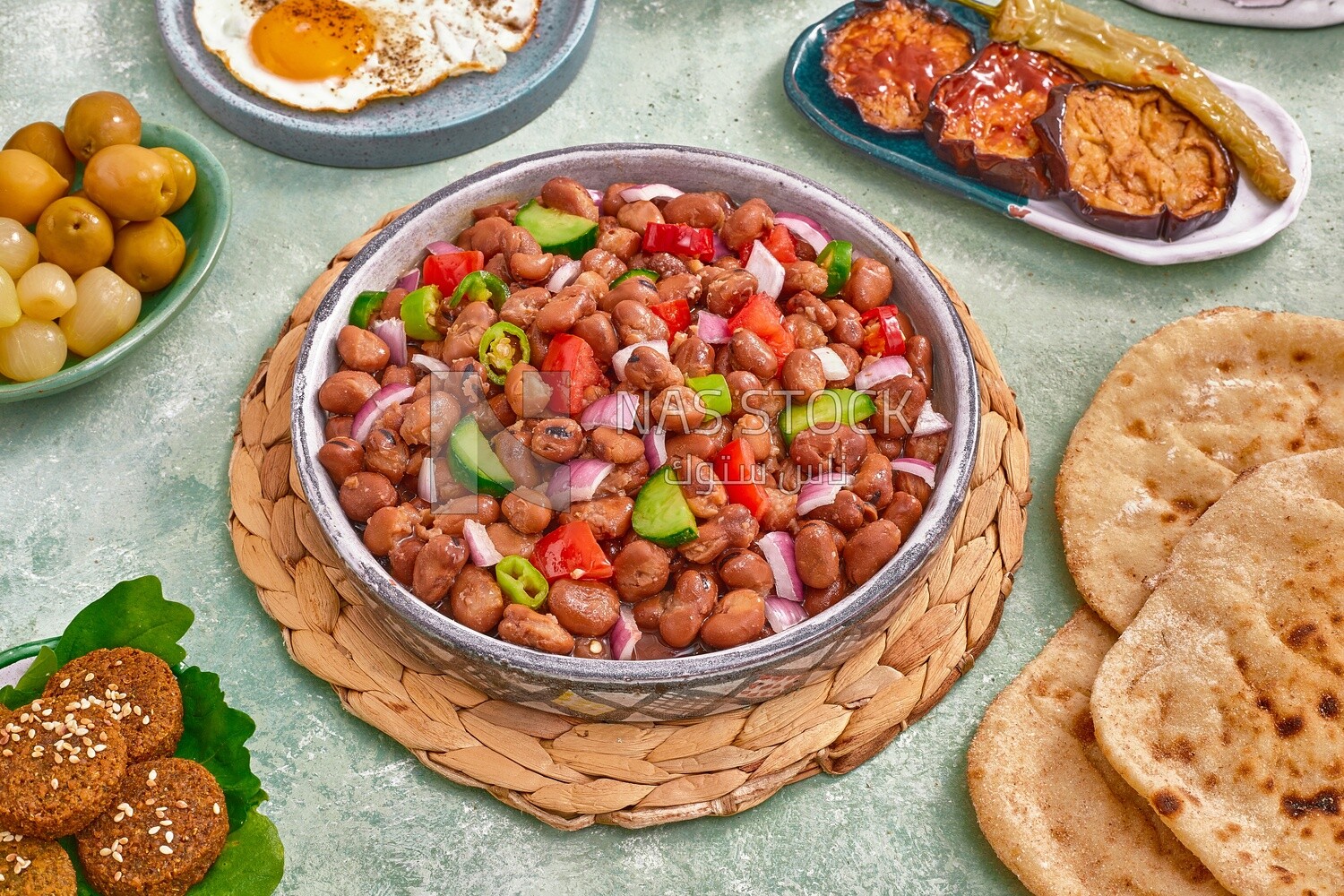 close-up of a dish of foul medames with vegetables, falafel tablets, a plate of fried egg, Arabic breakfast, oriental breakfast, arab restaurant