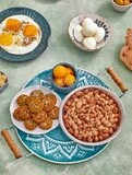 Close-up of oriental breakfast, a dish of foul medames, falafel tablets, a plate of fried egg, a plate of Boiled egg, Arabic breakfast, arab restaurant