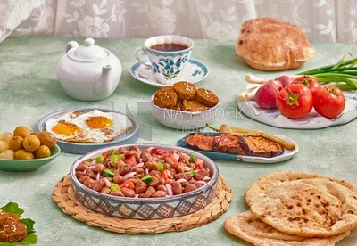 Close-up of a dish of foul medames with vegetables, falafel tablets, a dish of fried egg, fried eggplant Arabic breakfast, oriental breakfast, arab restaurant
