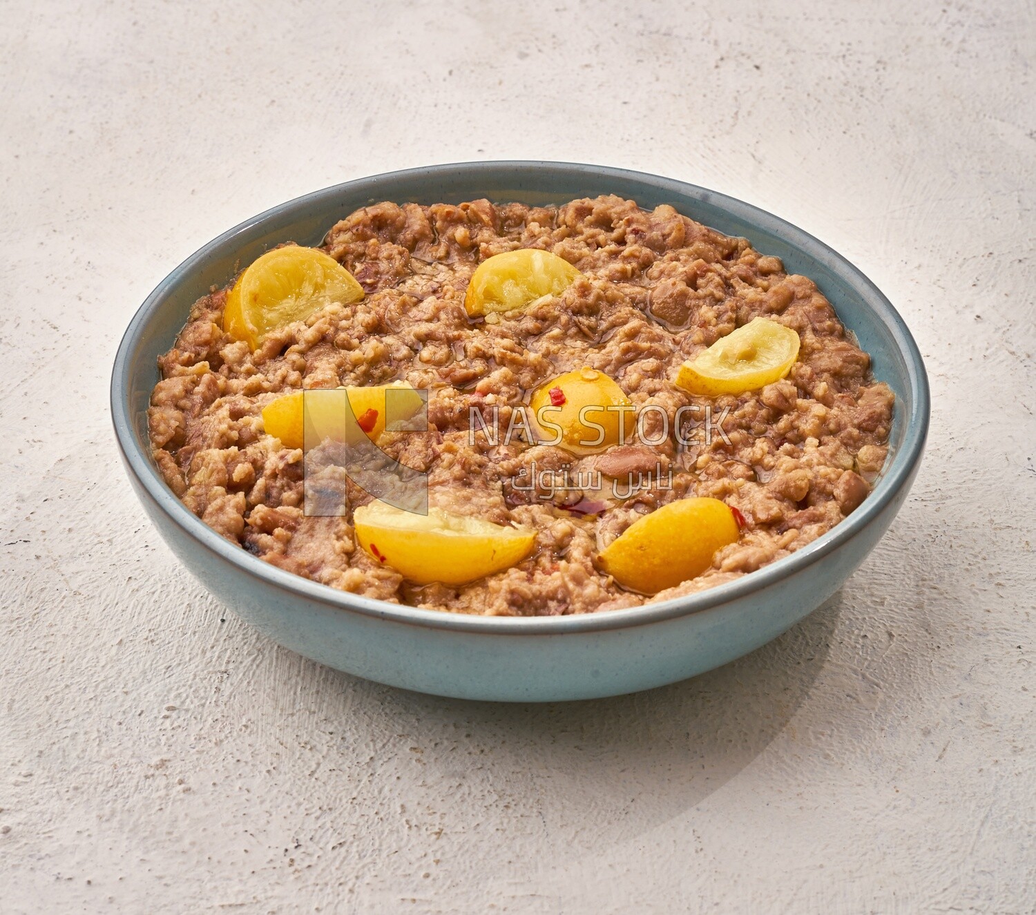 Close-up of oriental breakfast, a dish of foul medames with lemon slices, Arabic breakfast, arab restaurant
