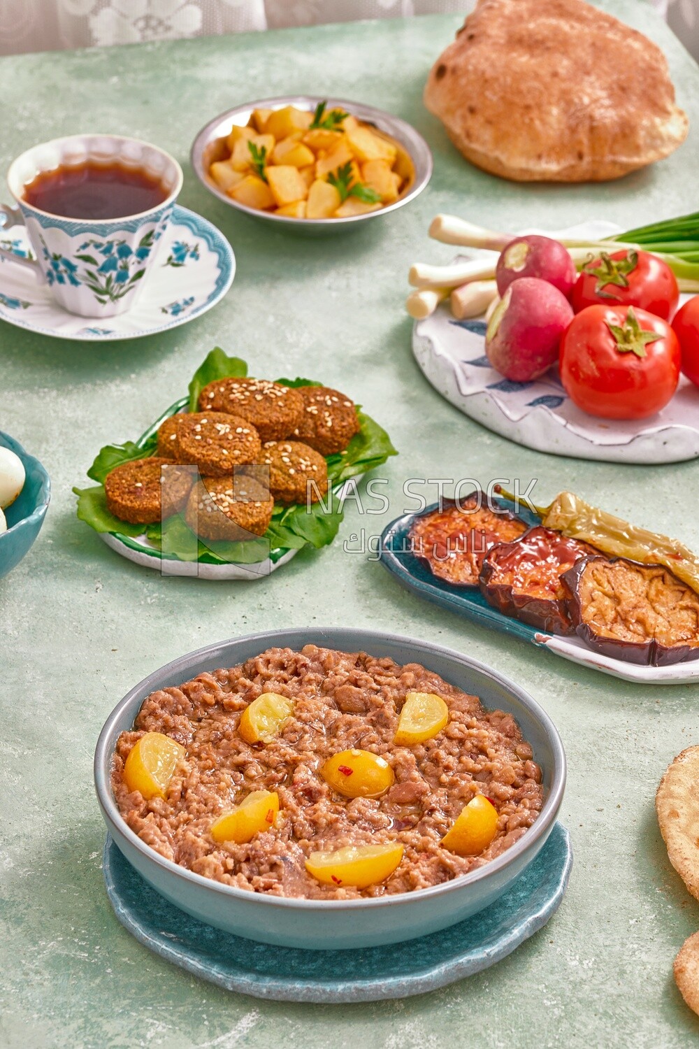 Dish of foul medames, falafel tablets, a plate of fried eggplant, Arabic breakfast, oriental breakfast, arab restaurant