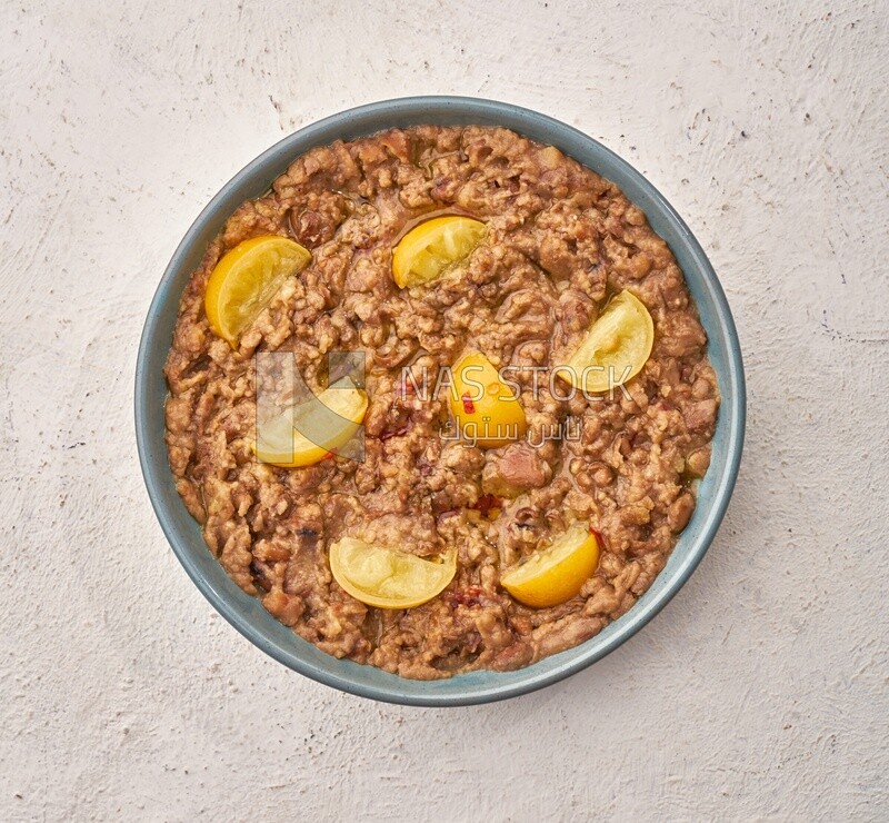 Close-up of oriental breakfast, a dish of foul medames with lemon slices, Arabic breakfast, arab restaurant