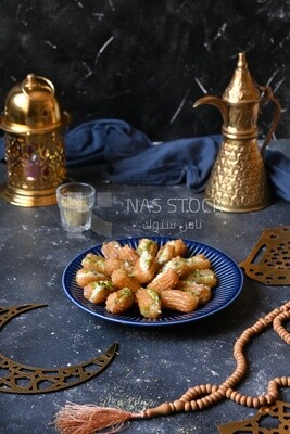 Tulumba with cream in it beside nuts, eastern sweets, Arabic Restaurant