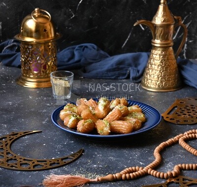 Tulumba with cream in it beside nuts, eastern sweets, Arabic Restaurant