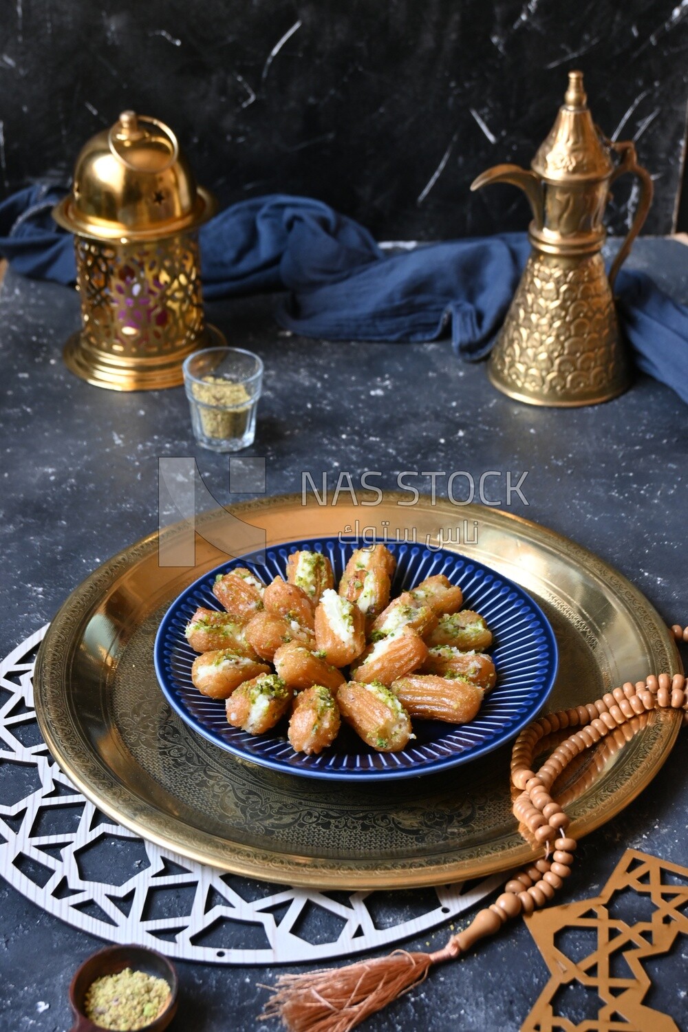 Tulumba with cream in it beside nuts, eastern sweets, Arabic Restaurant