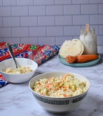 Bowl of Coleslaw beside the ingredients​ of it, cold appetizers, Arabic dishes, oriental foods