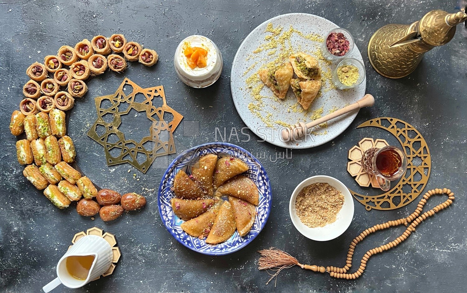 Cup of kunafa with mango and cream, plate of Qatayef with nuts, Baklava with nuts, oriental Arabic sweets, Ramadan sweets