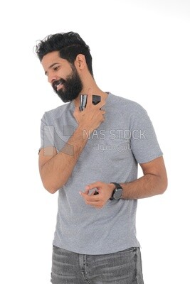 Saudi man holding a perfume bottle, applying perfume, selfcare, skin care and hygiene, Saudi model, white background
