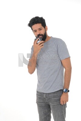 Saudi man holding a perfume bottle, applying perfume, selfcare, skin care and hygiene, Saudi model, white background