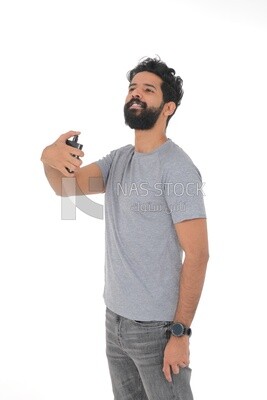 Saudi man holding a perfume bottle, applying perfume, selfcare, skin care and hygiene, Saudi model, white background