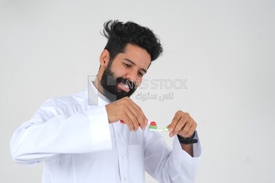 Saudi man holding a toothbrush, brushing his teeth with toothpaste, skincare and hygiene, self-care, Saudi model, white background