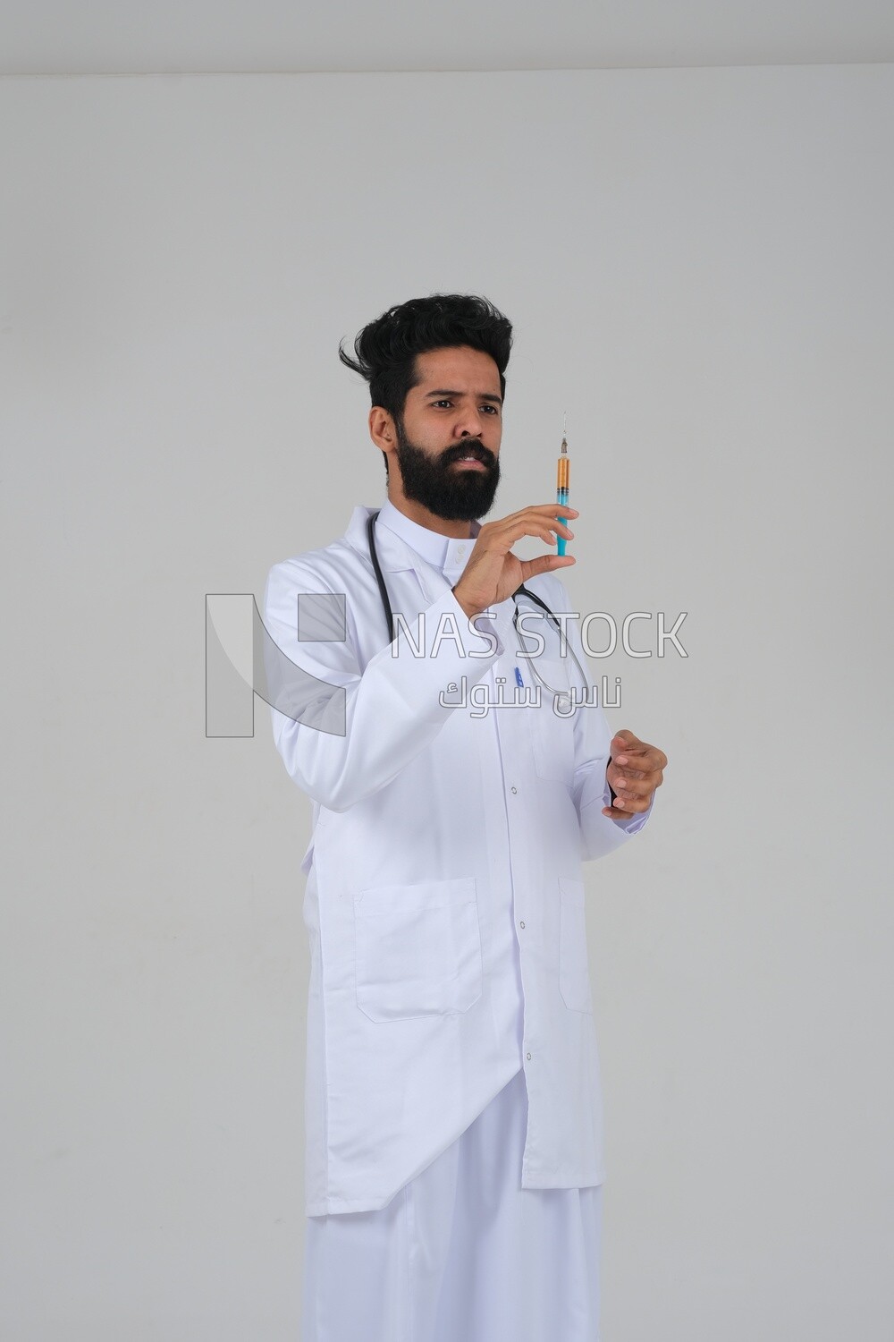 Saudi man wearing a medical coat and a stethoscope, holding a medical needle, white background, medicine and health care, Saudi model