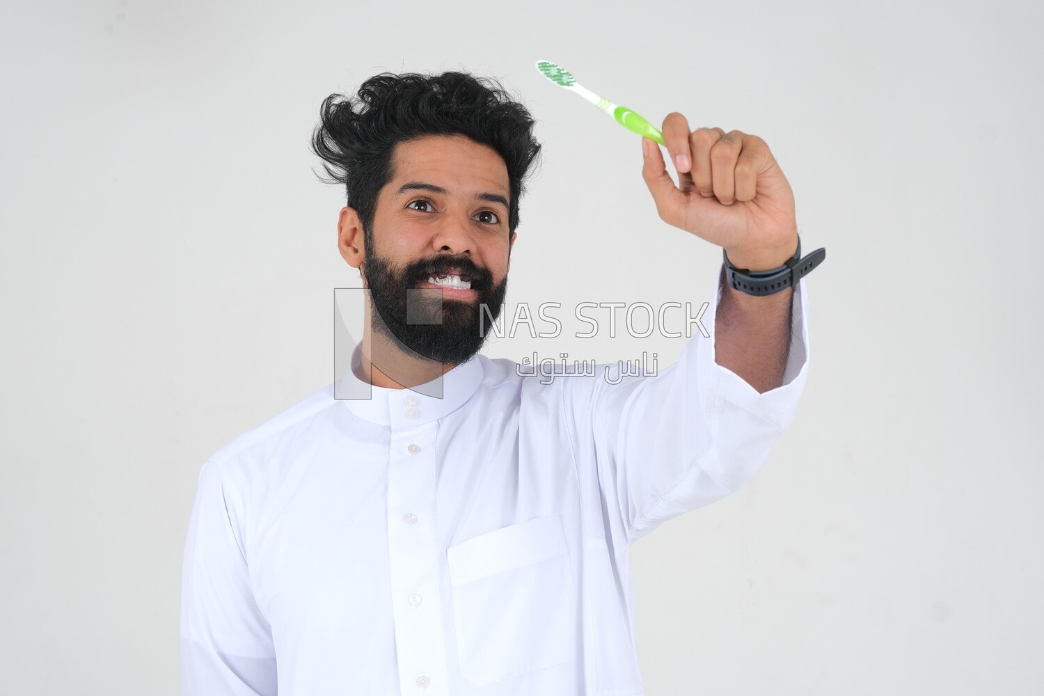 Saudi man holding a toothbrush, brushing his teeth with toothpaste, skincare and hygiene, self-care, Saudi model, white background