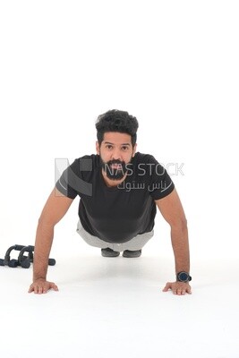 رجل سعودي يقوم بتمارين الإحماء ، والضغط ، وكمال الأجسام ، ونمط الحياة الصحي ، وبناء العضلات ، وخلفية بيضاء ، موديل سعودى