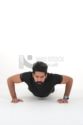 Saudi man doing warm-up exercises, push-ups, bodybuilding, healthy lifestyle, building muscle, white background, Saudi model
